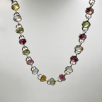 A sterling silver bracelet with numerous oval tourmaline drops, displayed against a white background.
