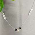 A sterling silver necklace with a group of three metallic disc pendants displayed on a mannequin's neck.