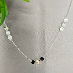 A sterling silver necklace with a group of three metallic disc pendants displayed on a mannequin's neck.