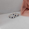Silver ring with blue gemstones on a white surface