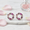 Pair of earrings with pink gemstones on a white background