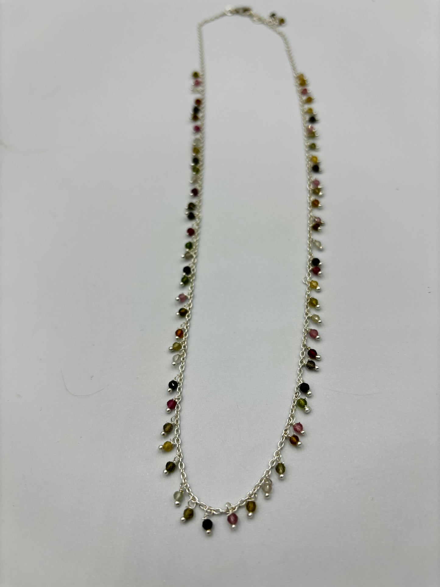 Sterling silver necklace with lots of tourmaline semi precious stones dangling on it