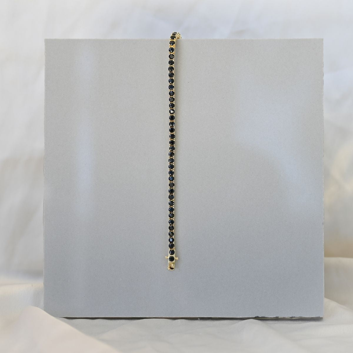 Gold tennis bracelet with black zirconia stones