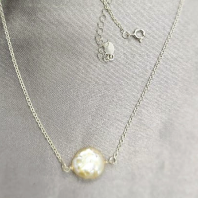 A sterling silver necklace with a chain design and a central freshwater pearl.