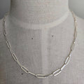 Silver chain necklace on a mannequin with a plain background