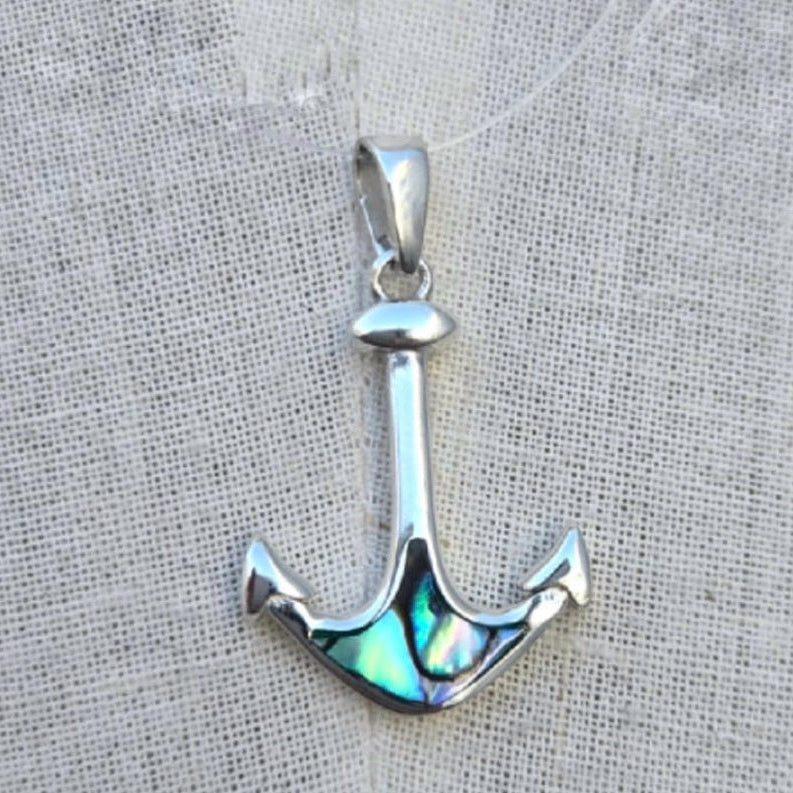 Silver anchor pendant with abalone shell inlay on a textured fabric background