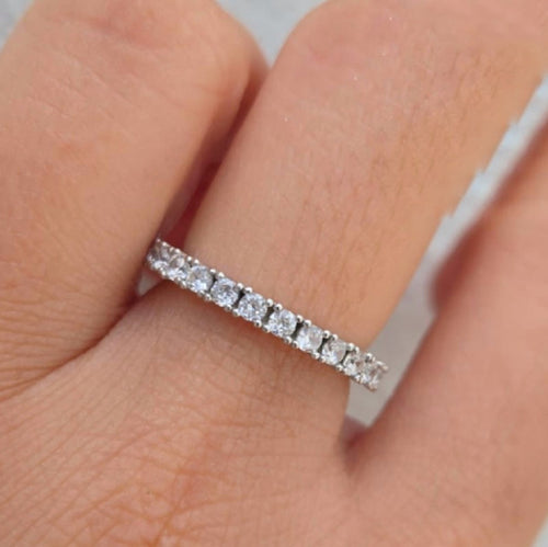 Diamond ring on a finger with a neutral background