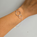 A sterling silver interlinked circle bracelet on a person's wrist, with a minimalist and elegant design.