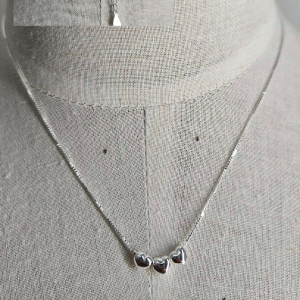Silver necklace with heart pendants on a mannequin