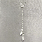 A sterling silver drop necklace with sparkling cubic zirconia, displayed on a grey background.