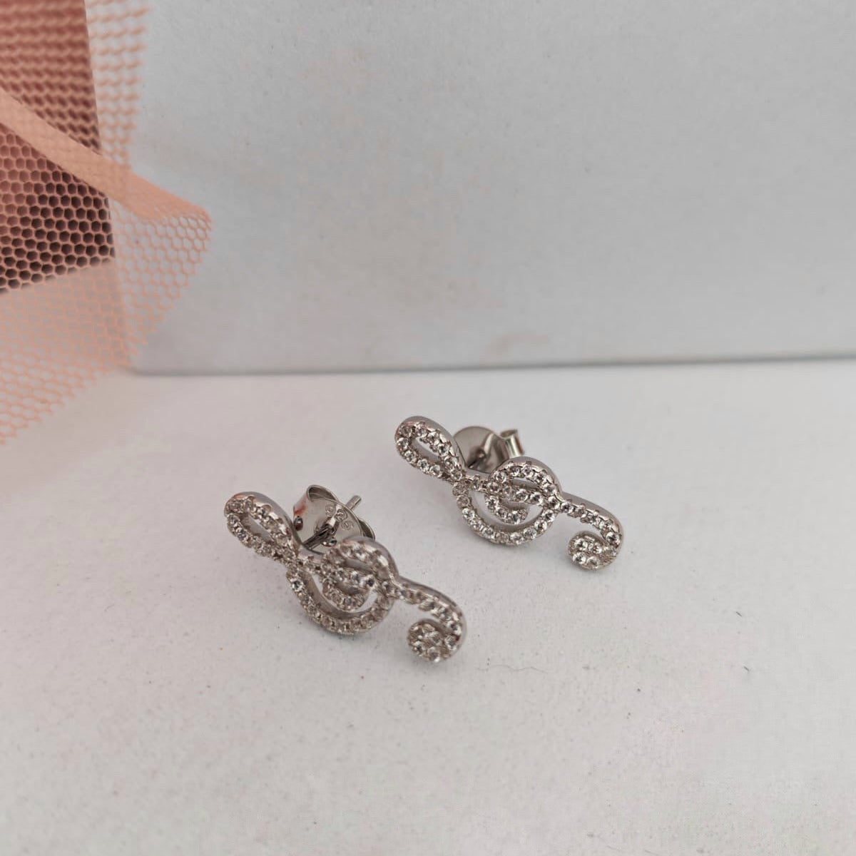 Pair of silver earrings on a light gray background
