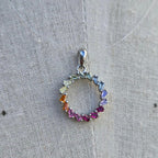 Multicolored gemstone pendant on a textured fabric background