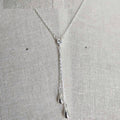 Silver necklace with a heart pendant on a light gray background