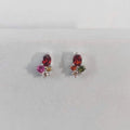 Pair of earrings with multicolored gemstones on a light gray background