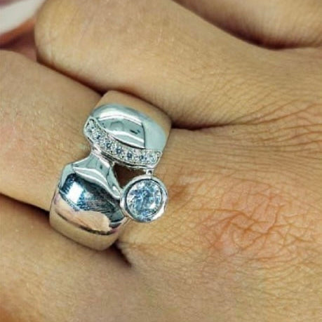 A sterling silver ring with a half circle detail and a central tube cubic zirconia, displayed on a person's hand.