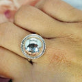 A sterling silver ring with a large 17mm ball and riffle detail on the edge, displayed on a person's finger.
