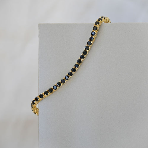 Gold tennis bracelet with black zirconia stones