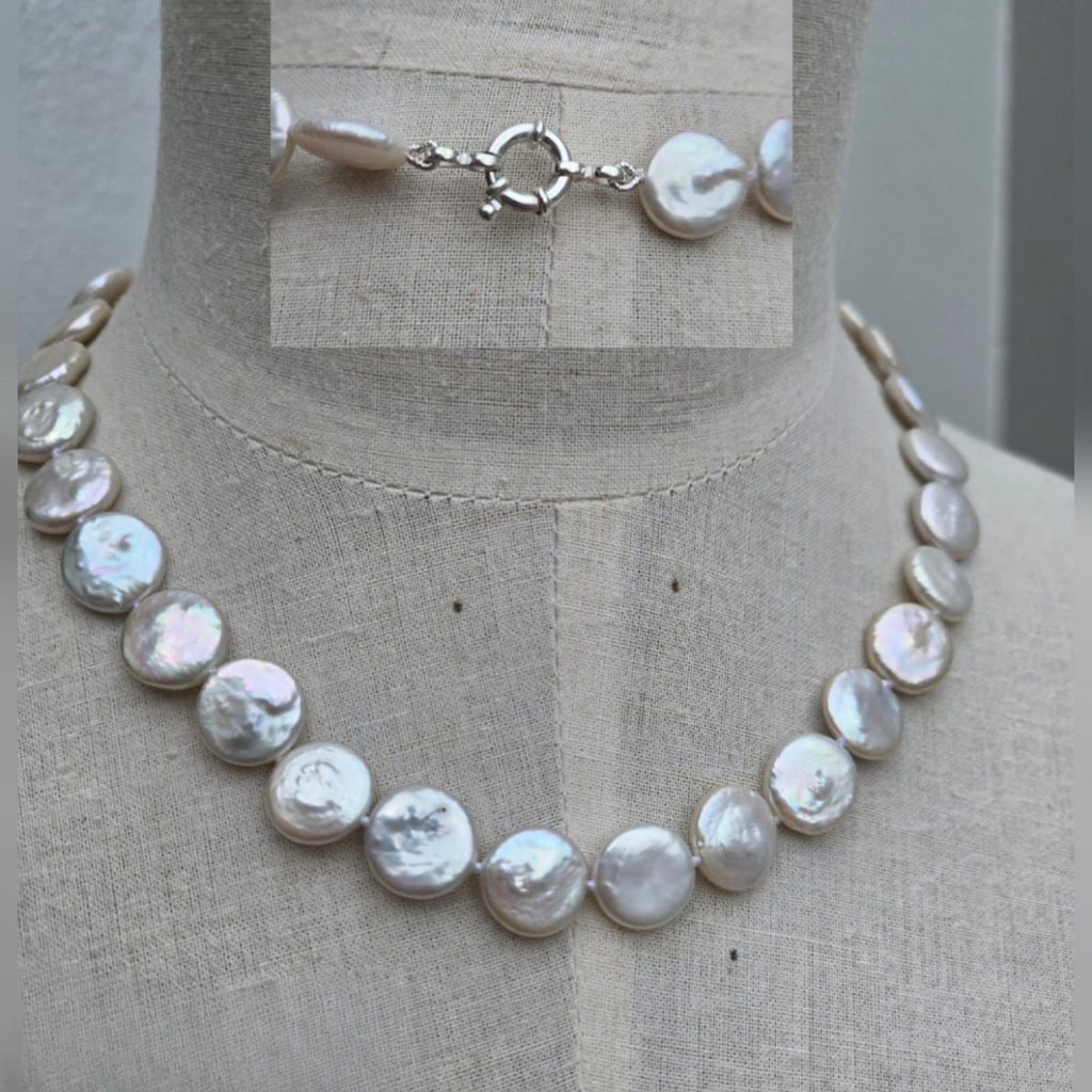 Pearl necklace on a mannequin with close-up inset showing clasp details.