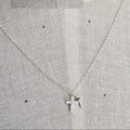 Silver star pendant necklace on a light gray fabric background