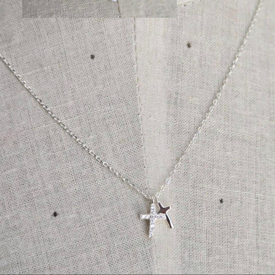Silver star pendant necklace on a light gray fabric background