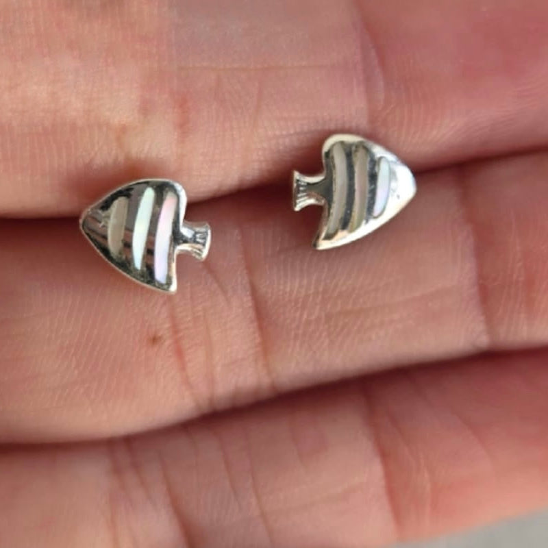 Silver fish-shaped earrings on a hand