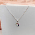 Necklace with a dog pendant on a light gray surface