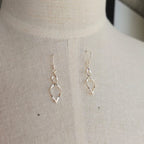 Gold earrings on a mannequin bust against a neutral background