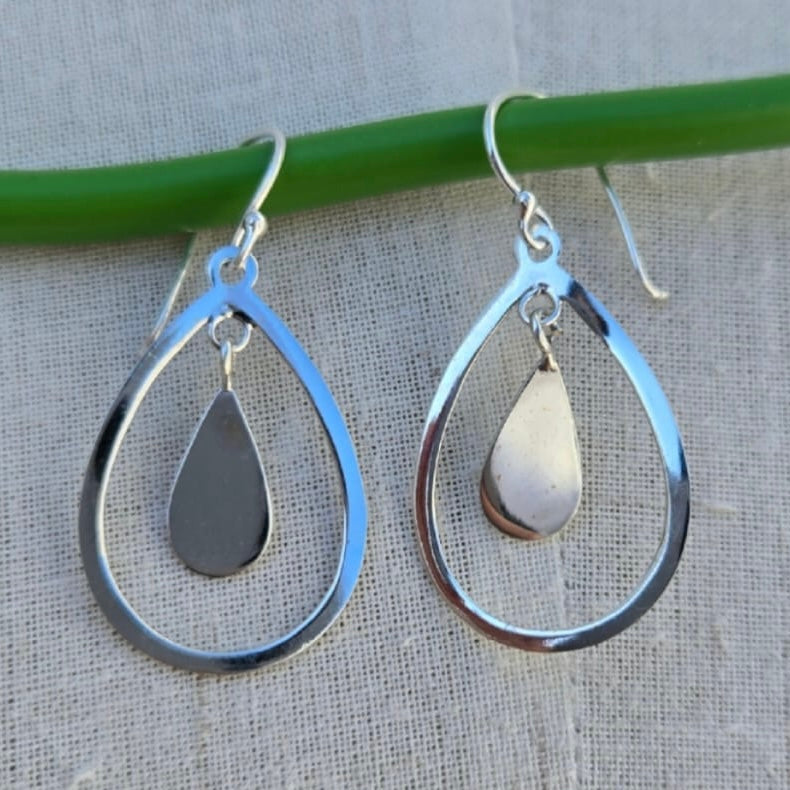 Silver teardrop earrings on a neutral background