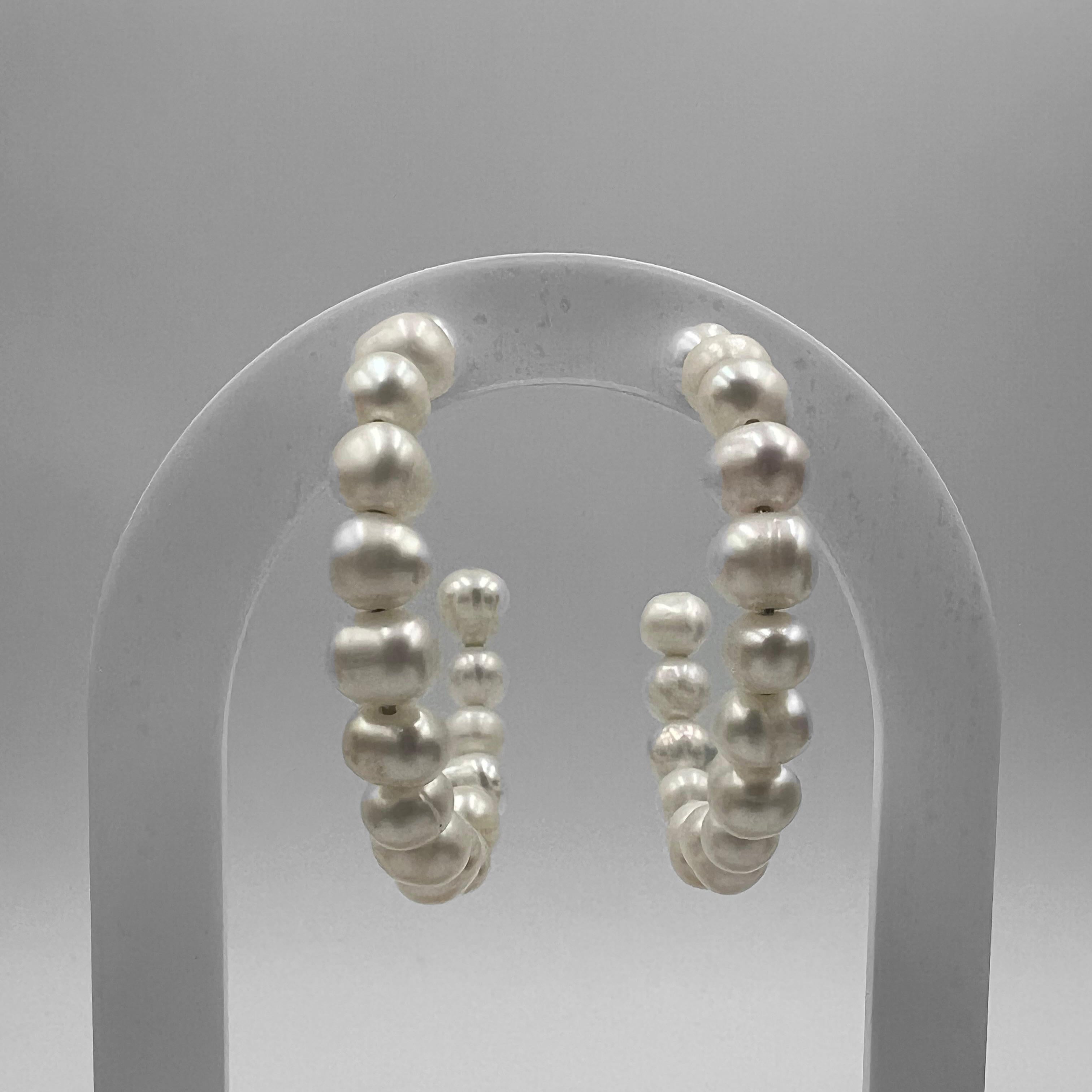 A pair of 40 mm hoop earrings featuring freshwater pearls, displayed against a grey background.