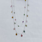 Necklace with multicolored gemstones on a light gray background