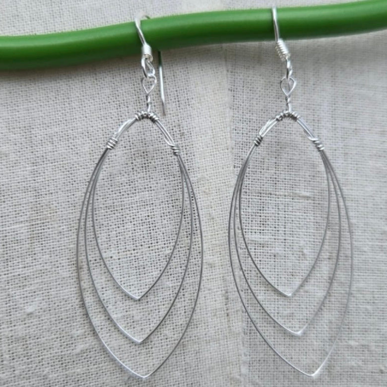 Silver hoop earrings on a gray fabric background