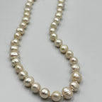 A white 7mm pearl necklace with sterling silver small ball links on a white background.