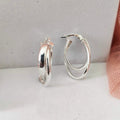 Pair of silver hoop earrings on a light gray surface