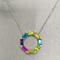 A sterling silver necklace with a multicolored baguette cubic zirconia stone circle pendant, displayed on a mannequin.