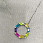 A sterling silver necklace with a multicolored baguette cubic zirconia stone circle pendant, displayed on a mannequin.