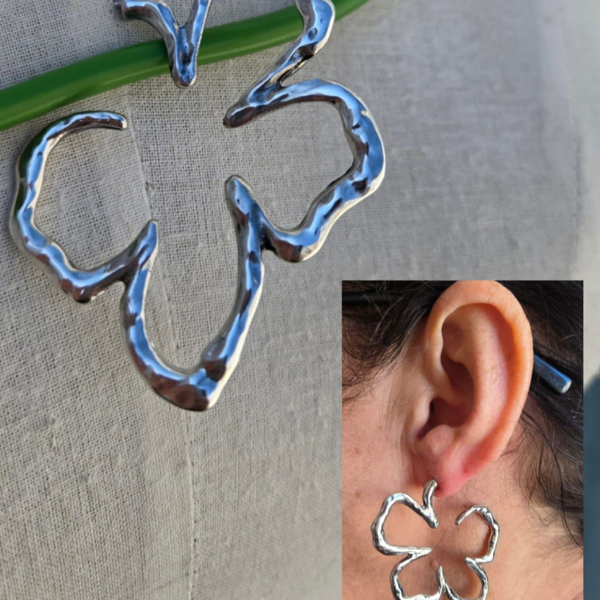 Silver four-leaf clover earrings on a gray background with an inset showing an ear wearing one of the earrings.