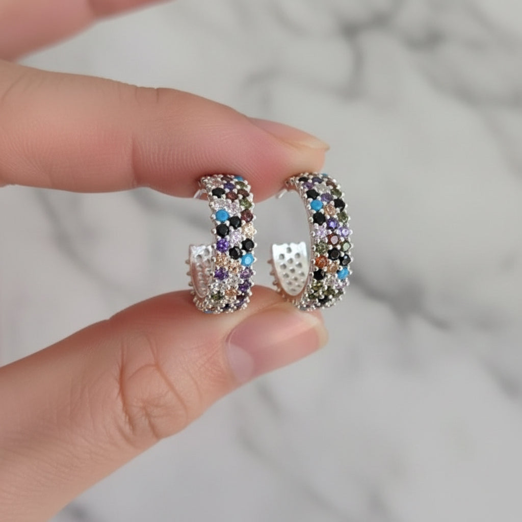 Multicolored beaded hoop earrings on a hand