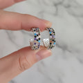 Multicolored beaded hoop earrings on a hand