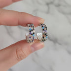 Multicolored beaded hoop earrings on a hand