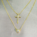 A gold-plated sterling silver double necklace with one layer featuring a small cross and the other layer featuring a larger solitaire cubic zirconia stone.