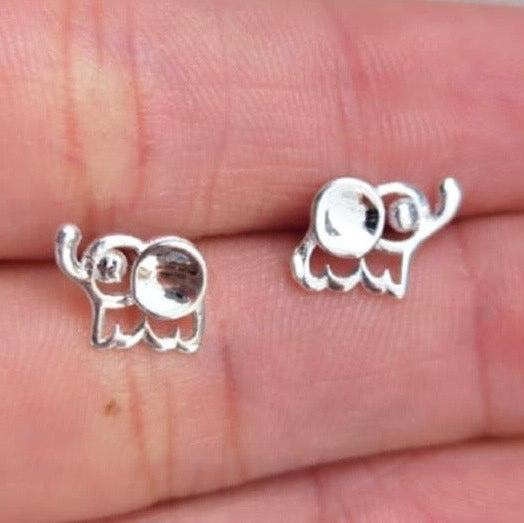 Silver elephant earrings on a hand