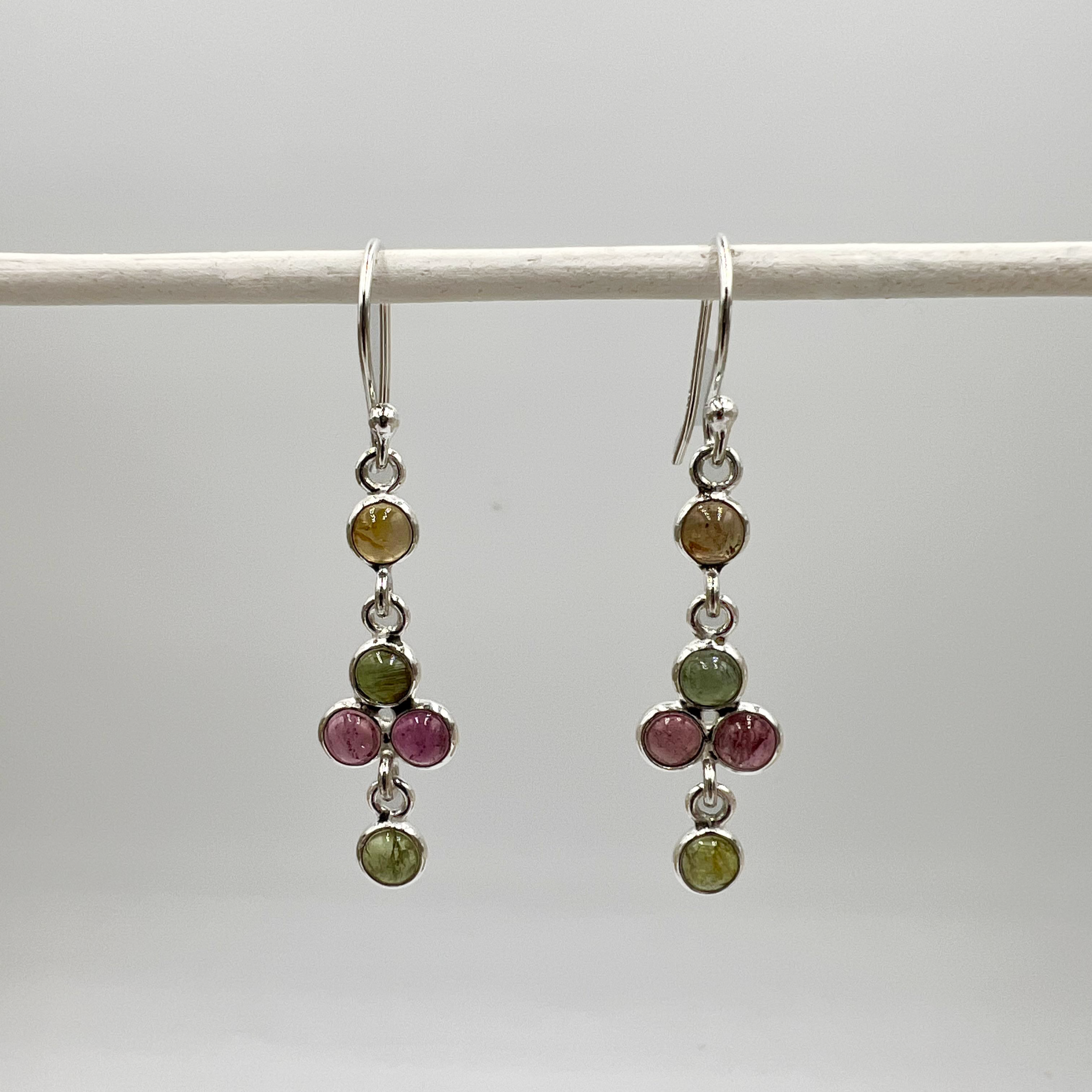 A pair of sterling silver drop earrings featuring multiple green and pink tourmaline semi-precious stones.