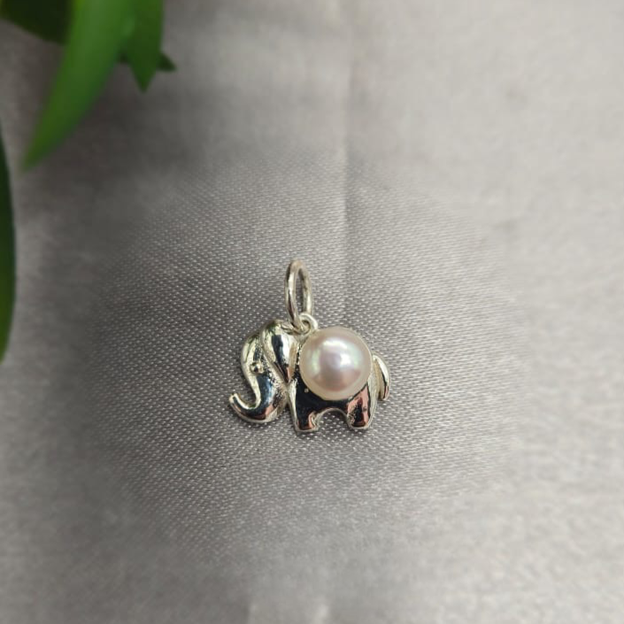 Silver elephant pendant with a pearl on a gray surface