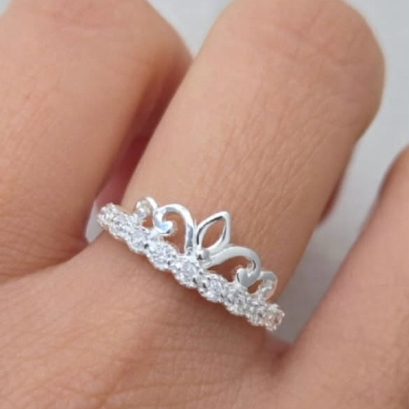 Silver tiara ring on a finger with a blurred background
