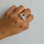 A sterling silver floral statement ring on a person's hand.
