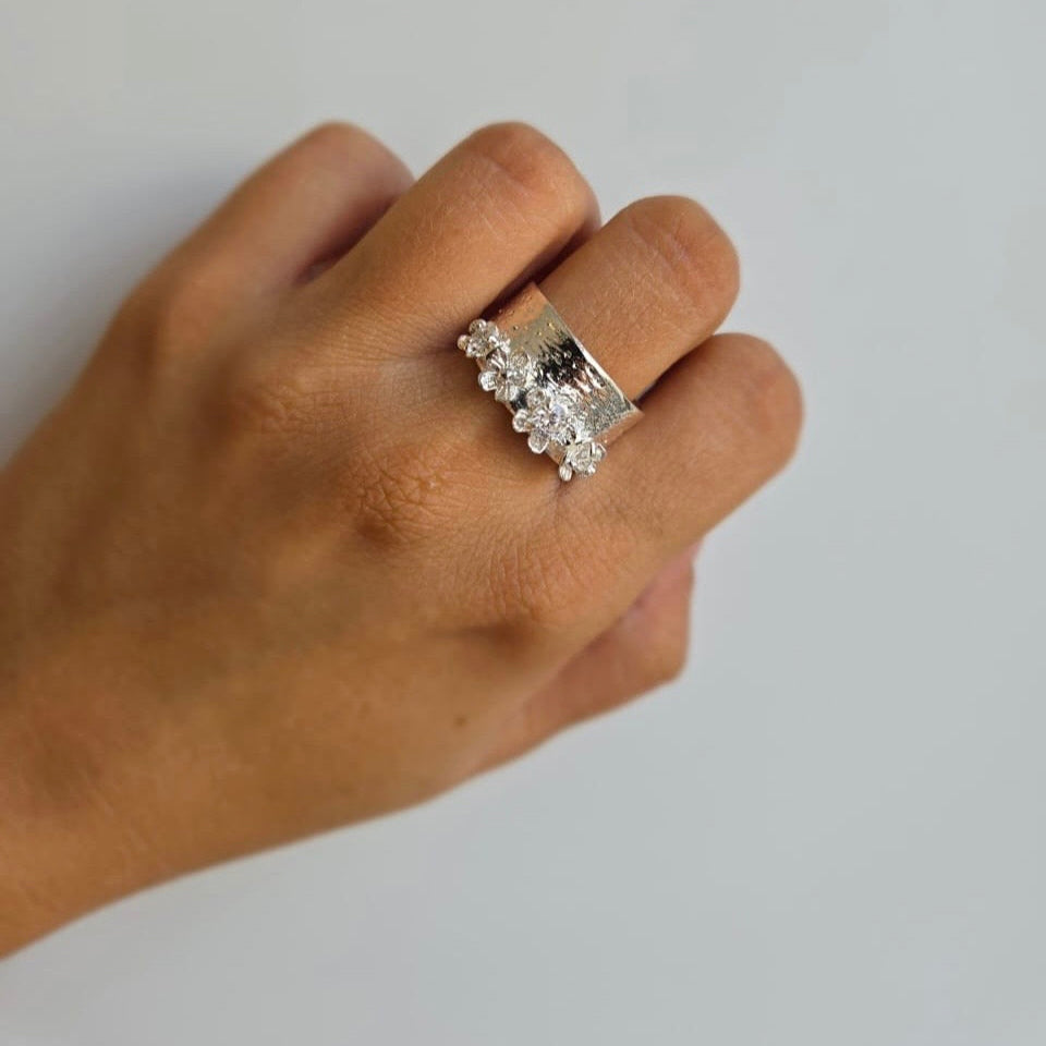 A sterling silver floral statement ring on a person's hand.