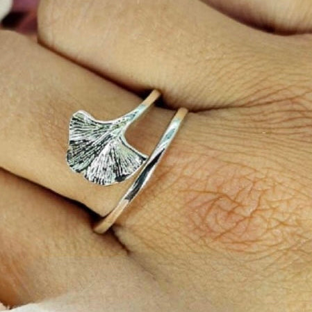 A sterling silver leaf ring on a person's finger, showing the intricate detailing of the leaf design.