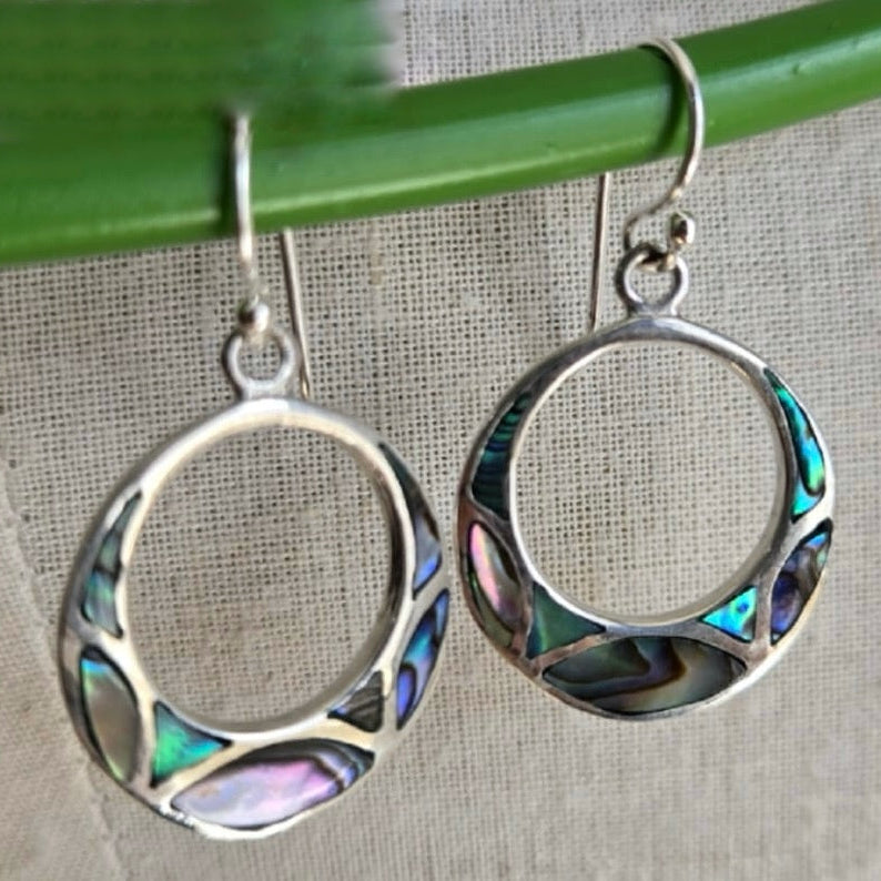 Silver hoop earrings with colorful inlay on a neutral background