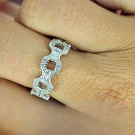 A sterling silver ring with cubic zirconia pavé cable design, held on a person's finger.