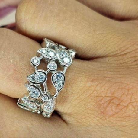 A sterling silver ring with a floral design and cubic zirconia embellishments, worn on a person's hand.
